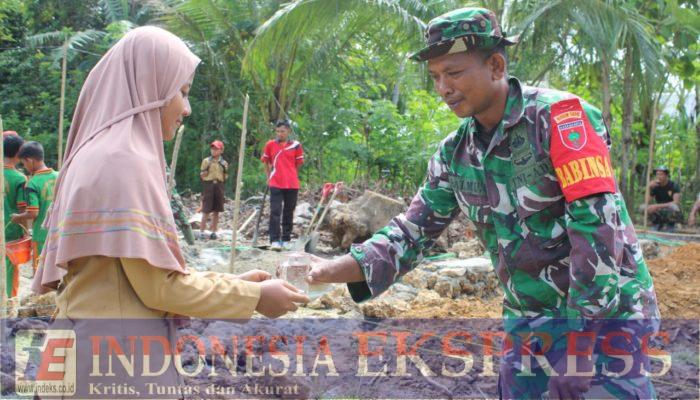 Dengan Keikhlasan dan Keceriaan, Pelajar SDN 5 Tiworo Tengah Menuangkan Minuman Kepada Anggota Satgas TMMD 123 Kodim 1416/Muna
