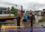 Babinsa Moncongloe Sigap Bantu Warga Terobos Jalan Tergenang Banjir di Maros